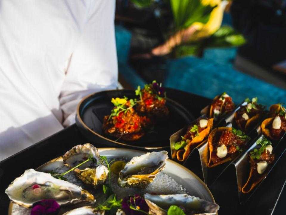 A waiter with a platter of oysters in Skybar 747