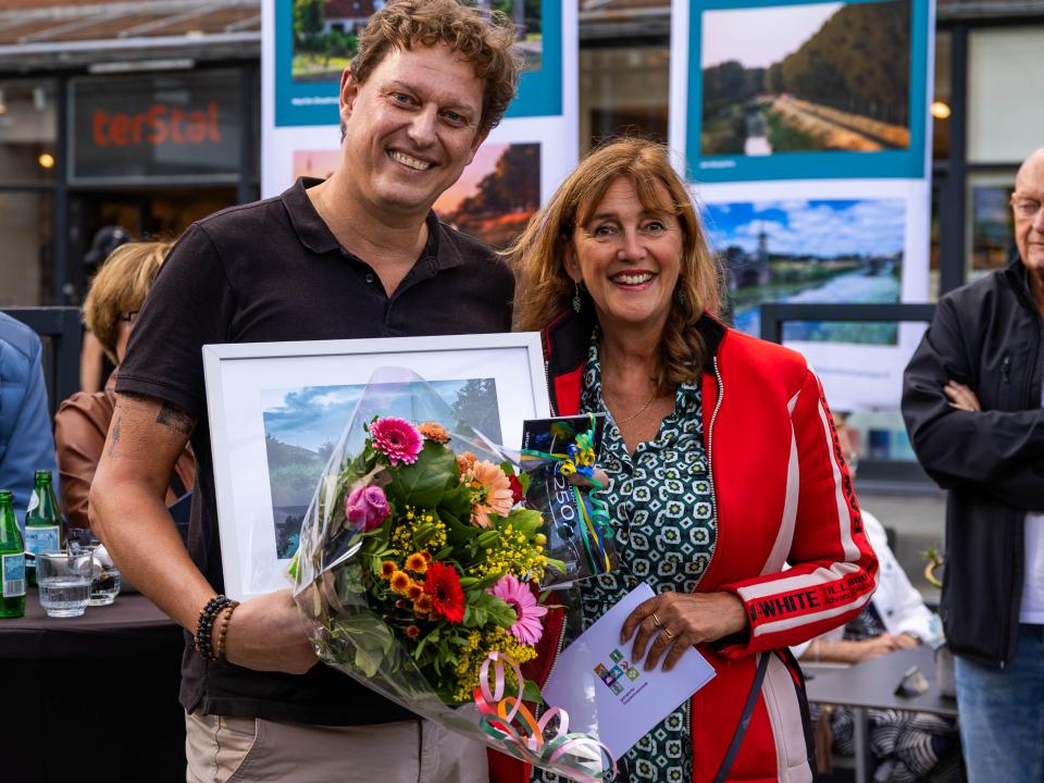Winnaar publieksprijs fotowedstrijd 2026 met wethouder Marja Ruigrok