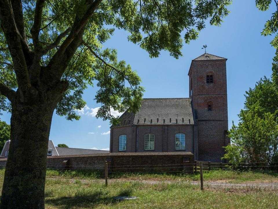 Buitenkant Stompe Toren tussen bomen door gezien