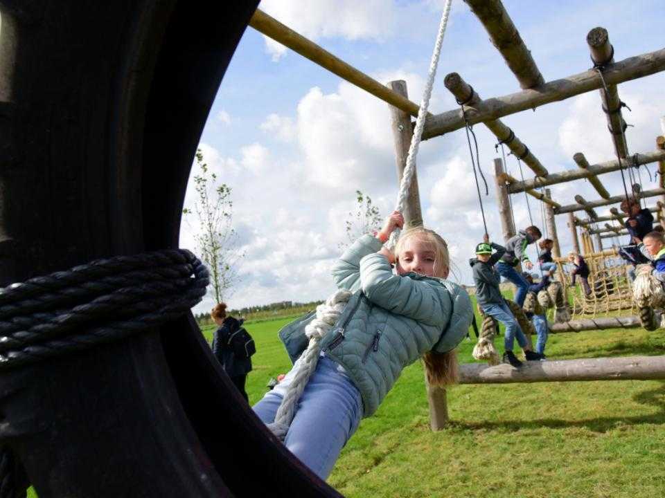 Meisje en andere kinderen in speeltoestel in park vijfhuizen