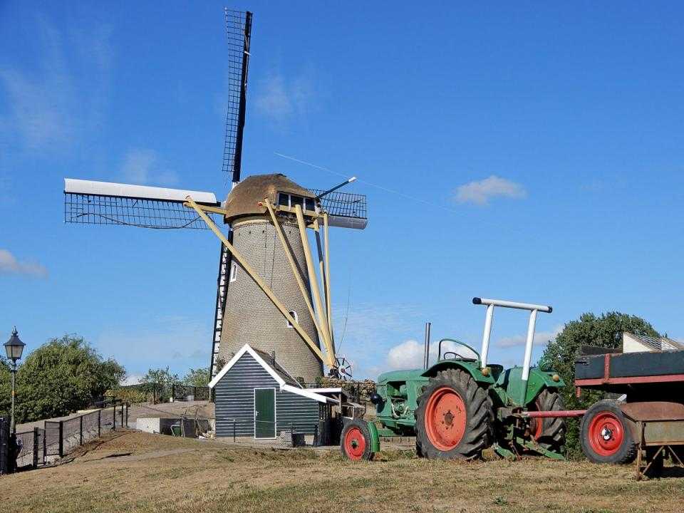 Molen de Eersteling with a green tractor and cart in the foreground