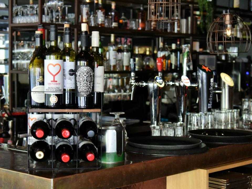 Bar met aantal wijnflessen bij bar bistro Joseph