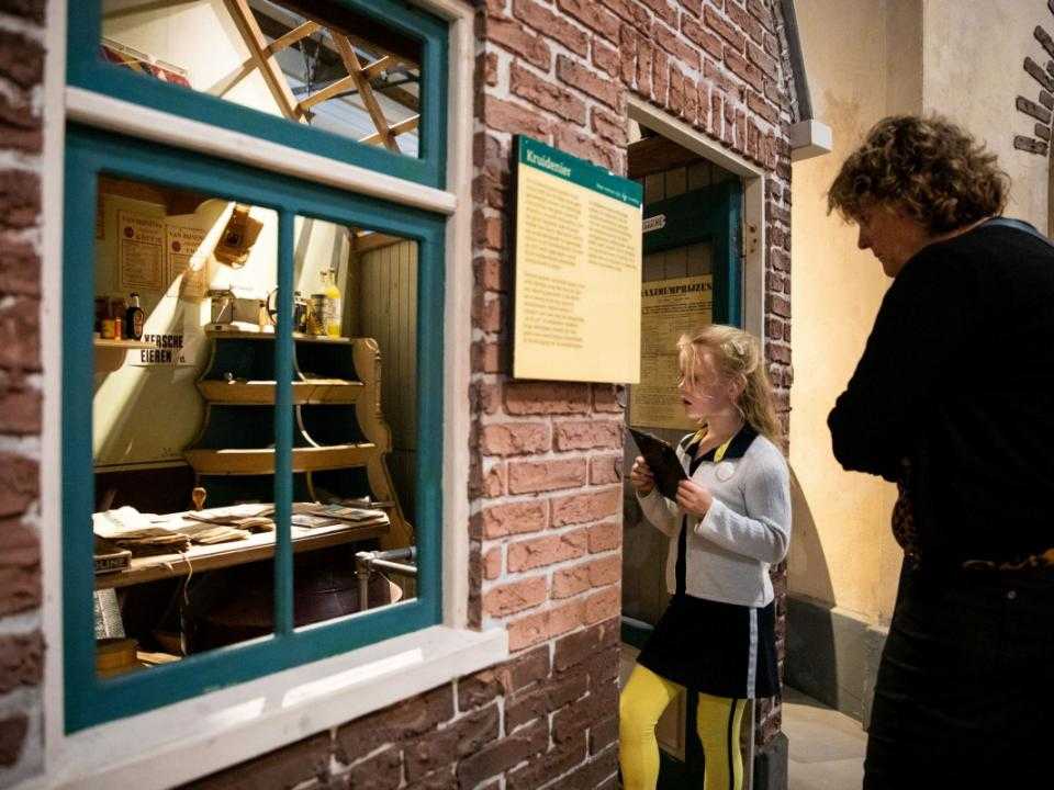 Girl looks through old shop window