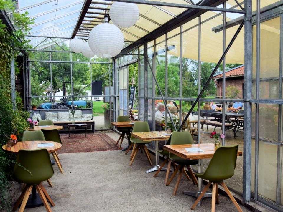 Interieur Fruitloods met stoelen en tafels in serre