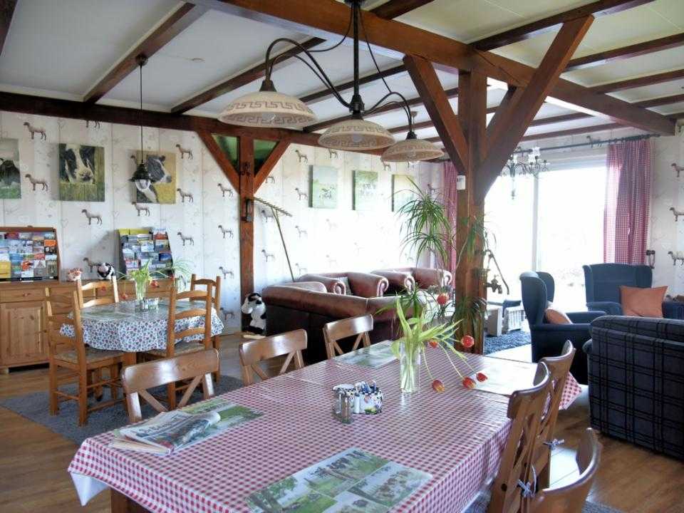 Interieur gezamenlijks woonkamer met grote eettafel bed en breakfast de Kaagse Koe