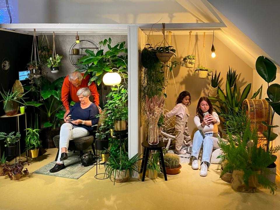 Bezoekers zitten in 2 zithoeken vol met planten en bloemen