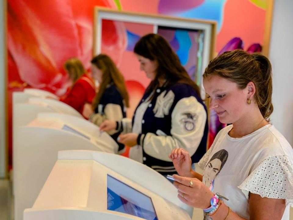 Bezoekers lezen info op digitale schermen bij Floriworld Aalsmeer
