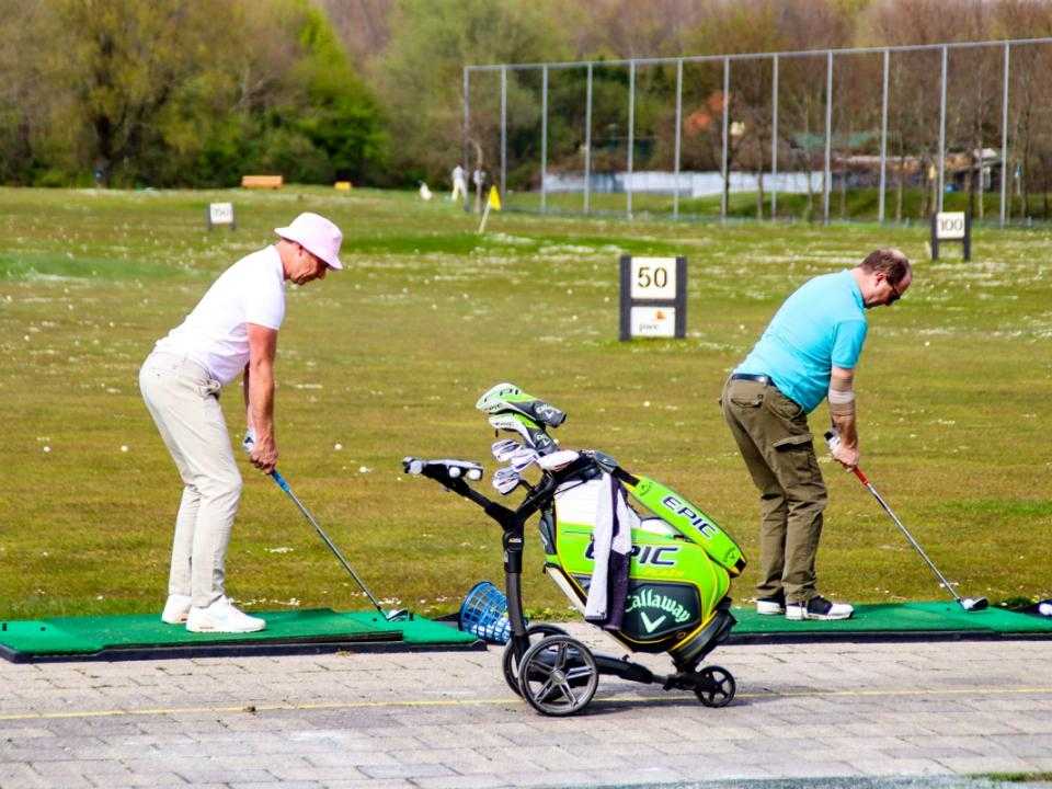 Golfers bij het afslaan op golfbaan Houtrak