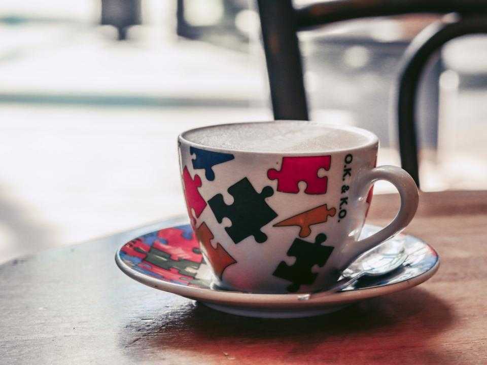 Kop koffie in kleurrijk kopje op tafel bij Bagels en Beans