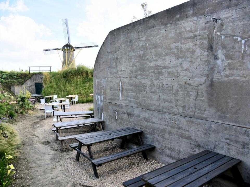 Buitenkant Fort met picknicktafels op achtergrond molen Eersteling
