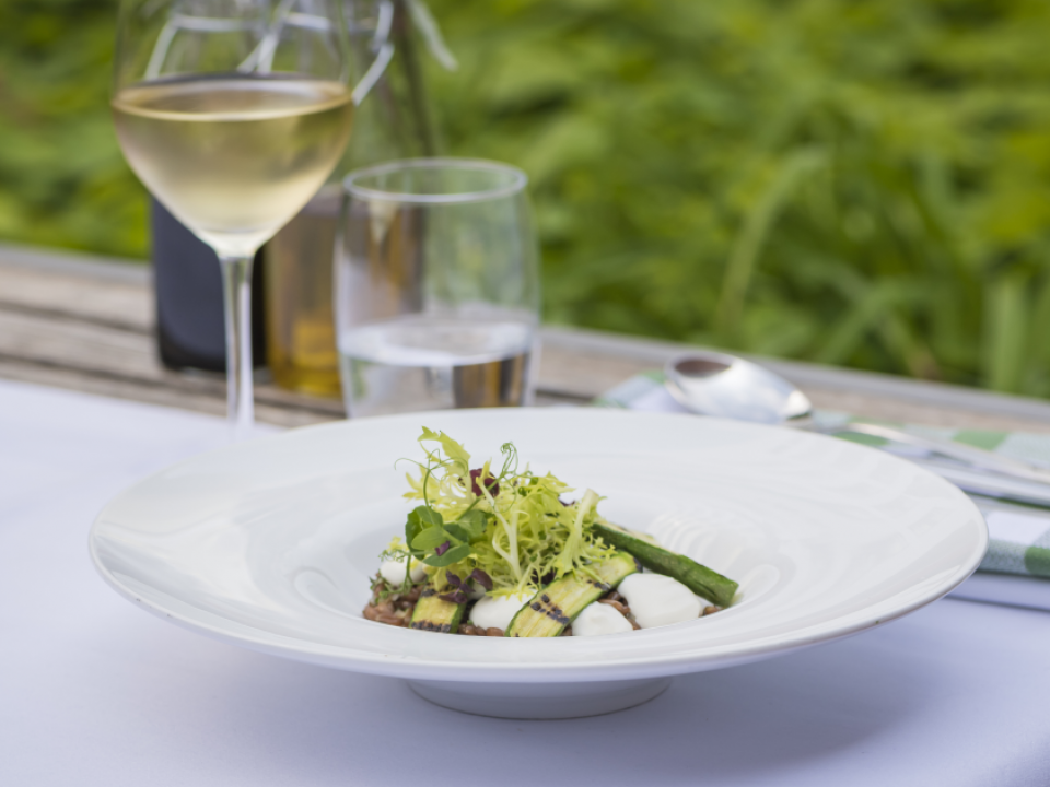 Tafel met bord met eten en glas wijn hotel steigenberger