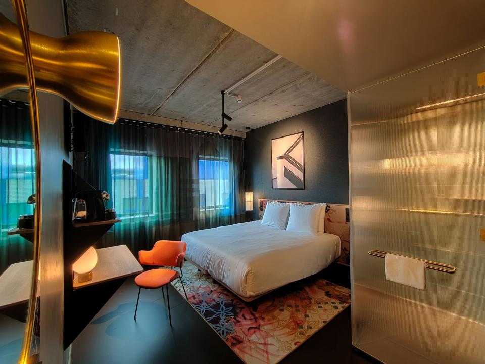 Interieur hotelkamer Florian met bed en oranje stoel aan tafeltje