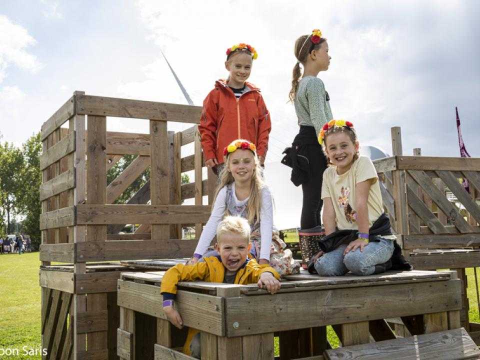 Children sit on wooden huts