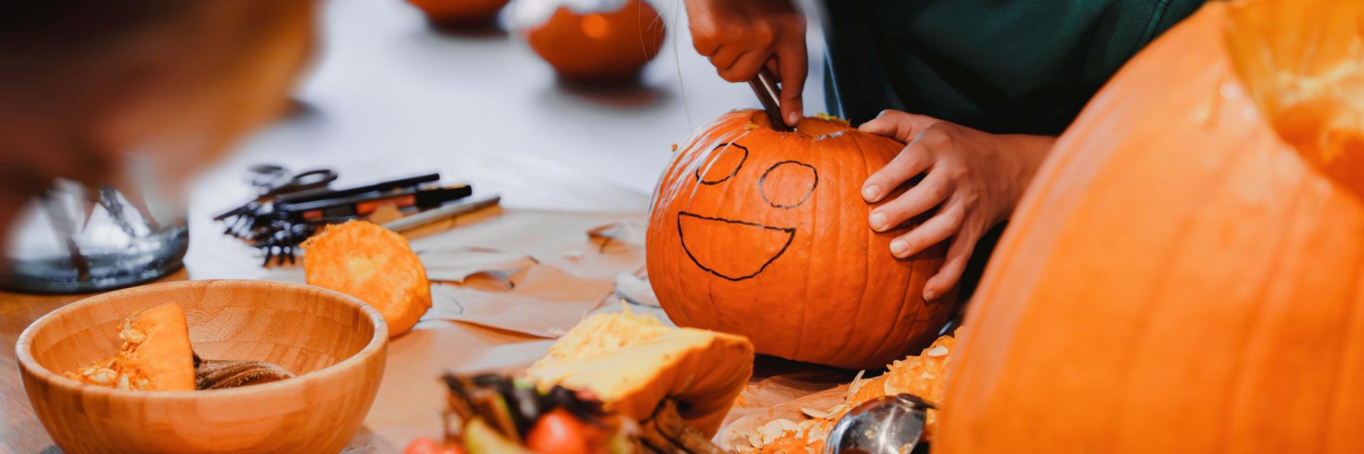 Kinderen die een halloweenpompoen uitsnijden