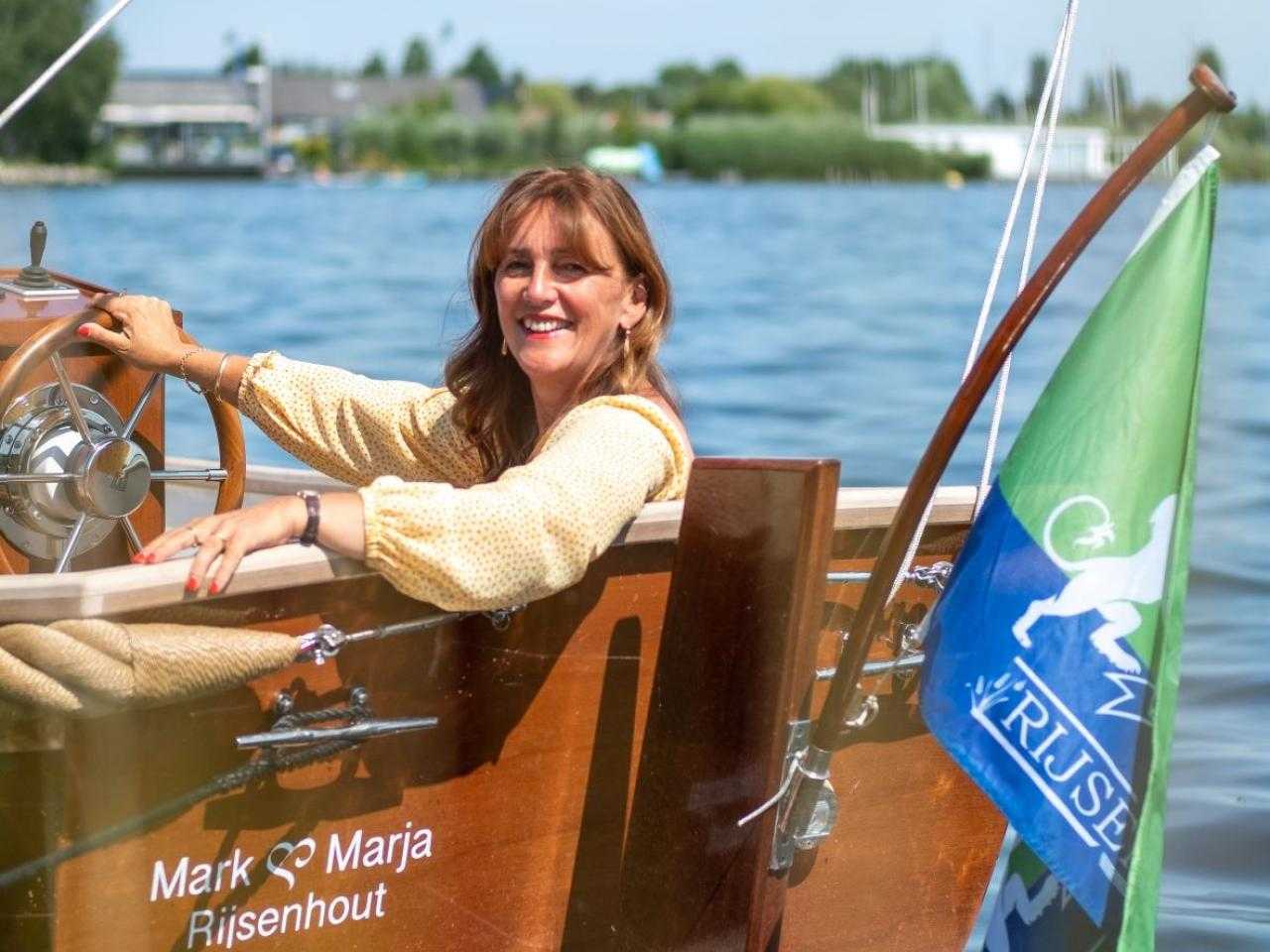 Marja Ruigrok aan het roer van haar sloep in Rijssenhout