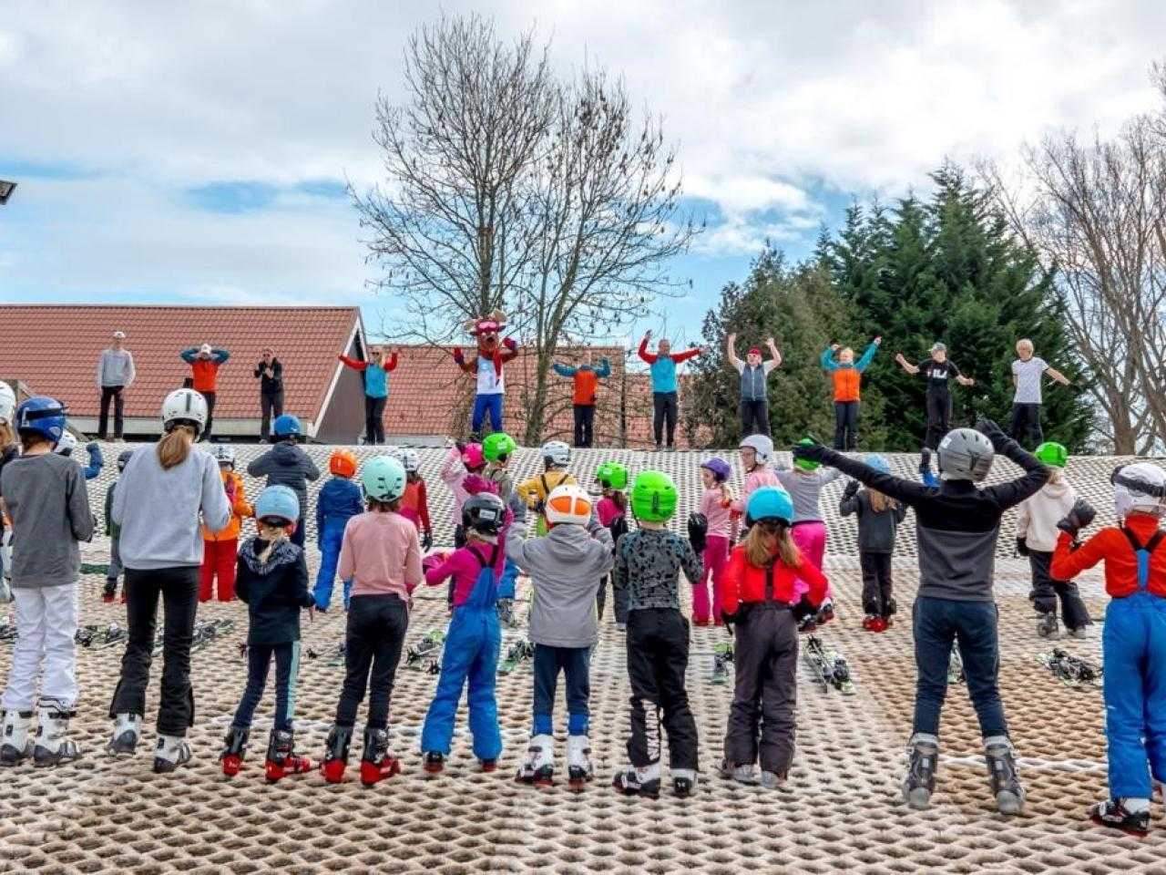 Kinderen op buitenpiste tijdens les bij Skicentrum hoofddorp