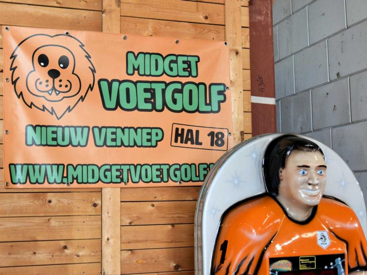 Cloth with text Midget footgolf and plastic doll in front of it