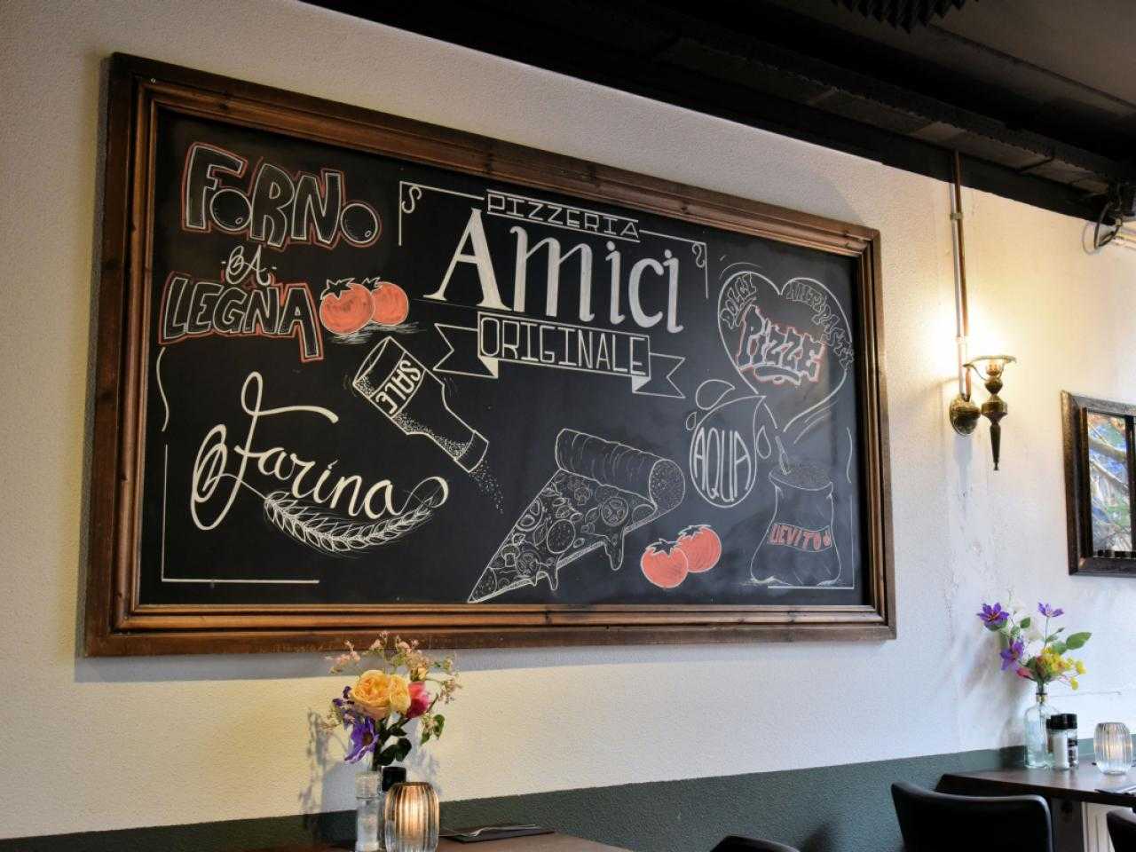 Chalkboard on wall of pizzeria Amici