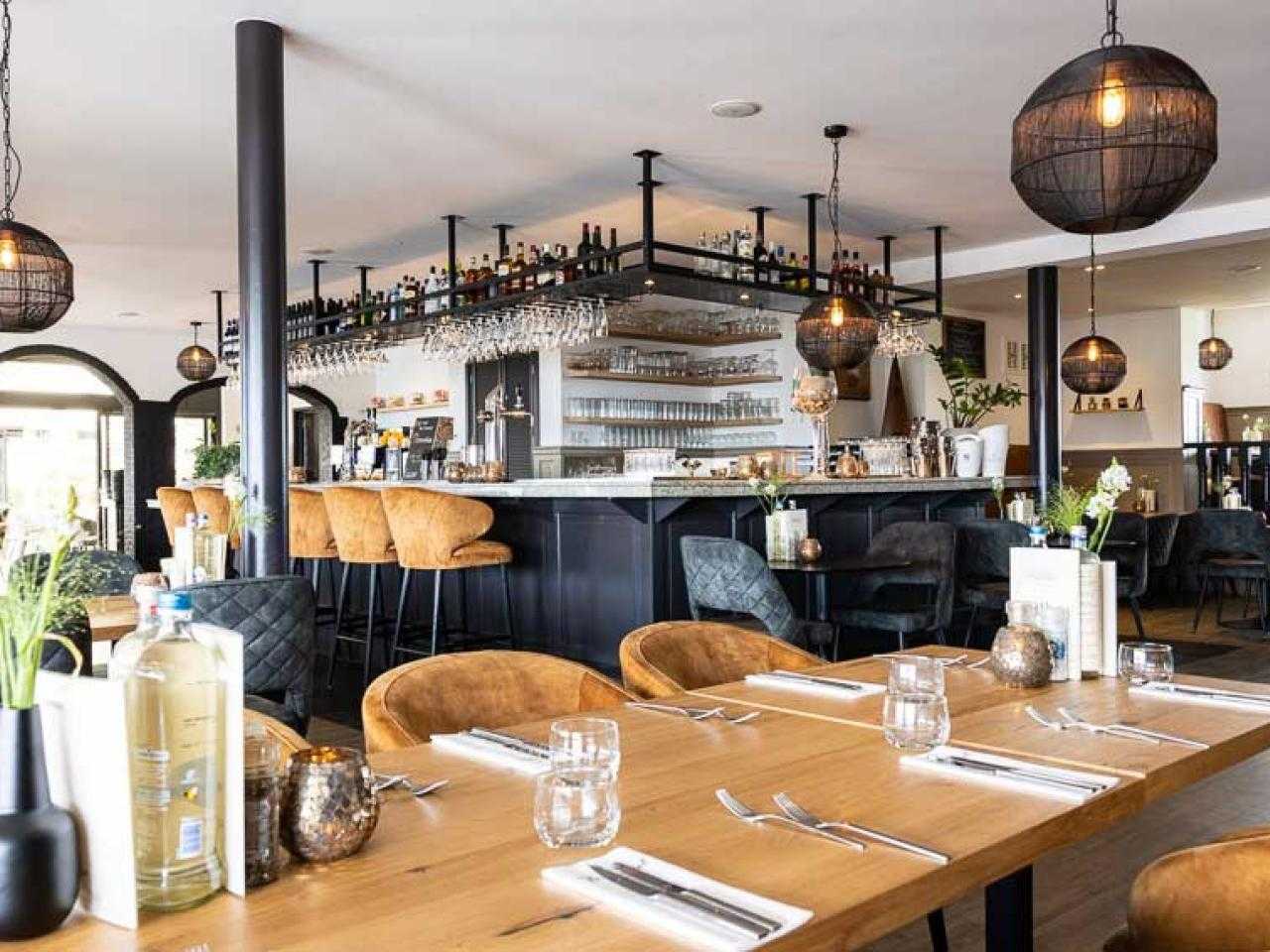 Restaurant vanbinnen met gedekte tafels