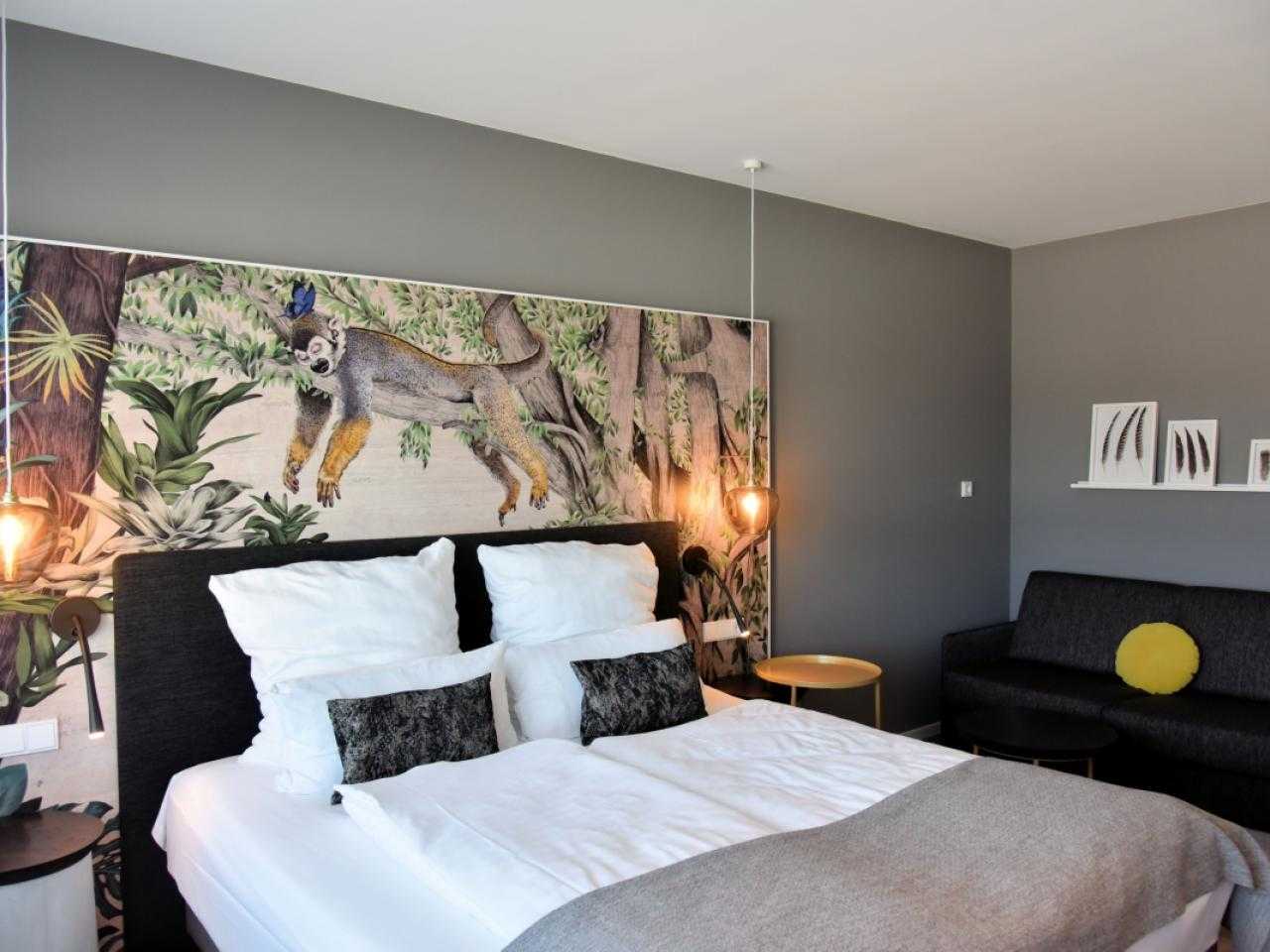 Interieur hotelkamer met jungle behang achter bed, Ninety Nine hotel
