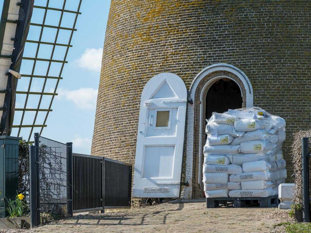Entrance to Molen de Eersteling with a large pile of sacks of flour in front of the entrance