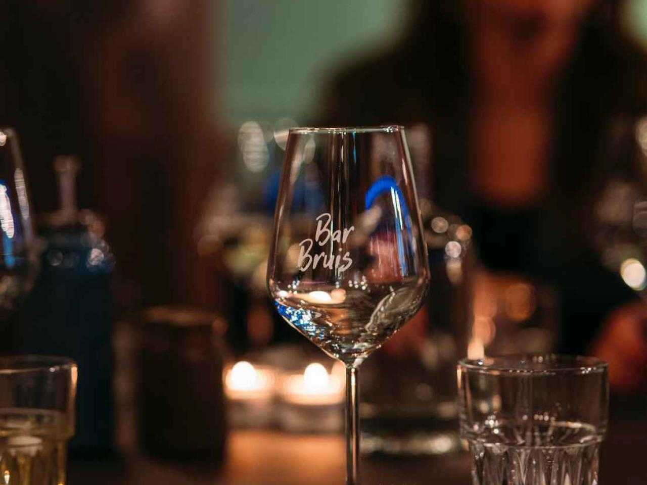 een foto van een wijnglas met het logo van bar bruis