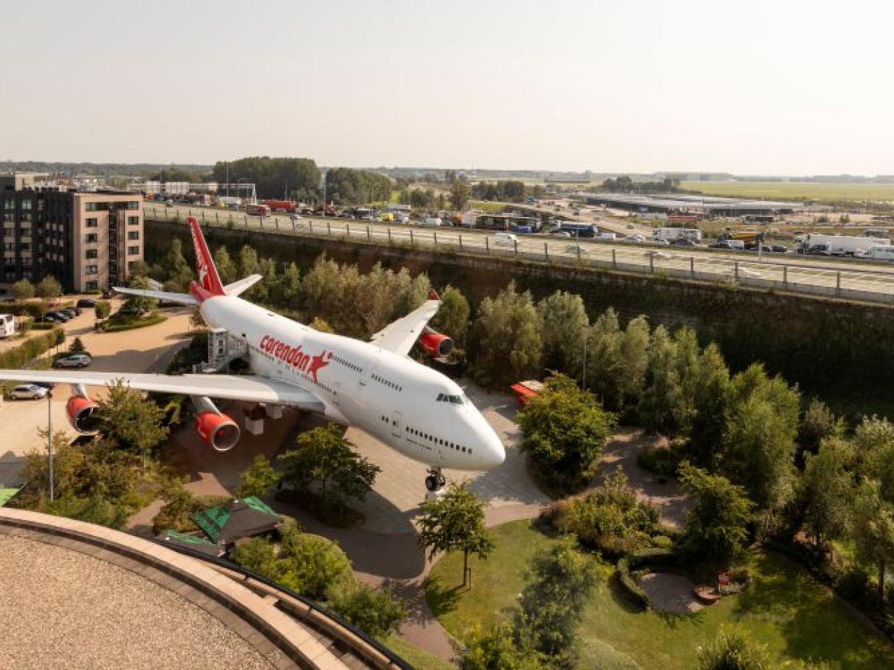 Bovenaanzicht van het hotel met Boeing 747 in de tuin