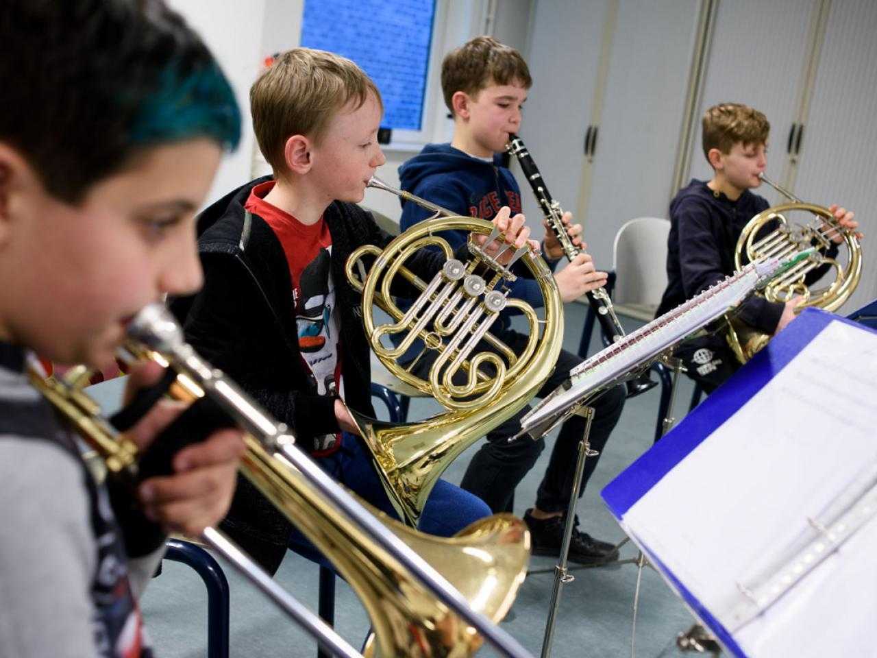 Kinderen maken muziek op een blaasinstrument