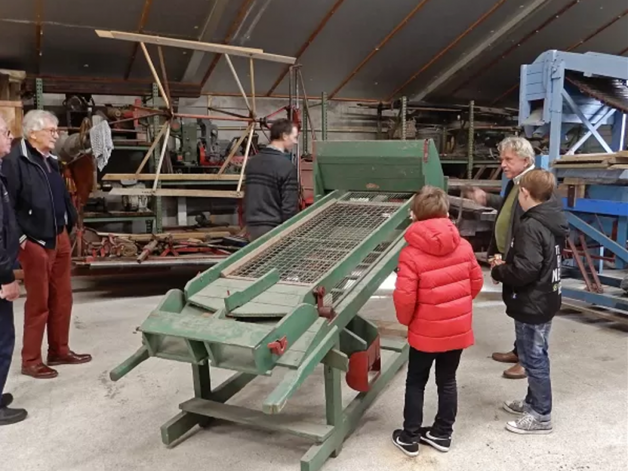 Mensen bij een agrarisch werktuig