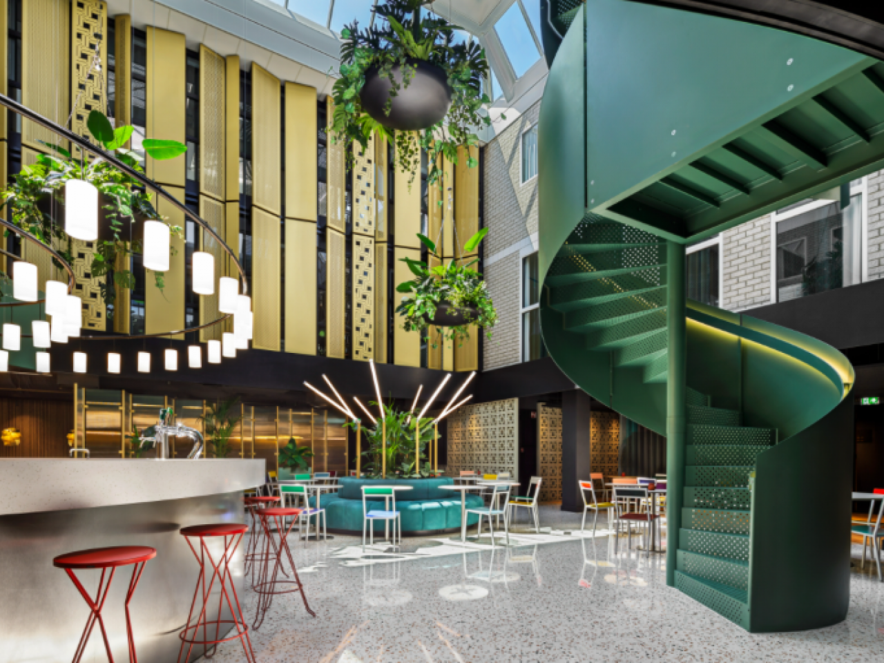 Lobby hotel Florian met groene wenteltrap en bar en banken met mooie verlichting