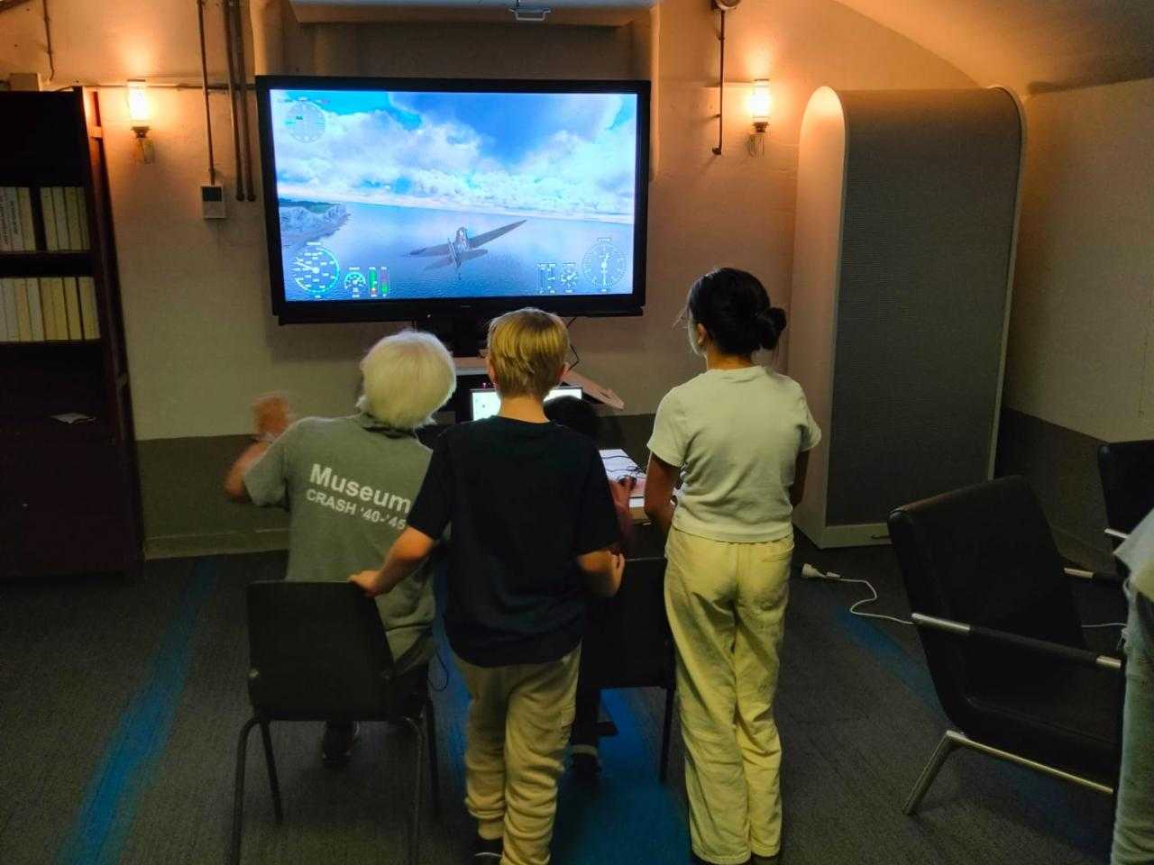 Begeleider en kinderen aan het vliegen op de flight simulator