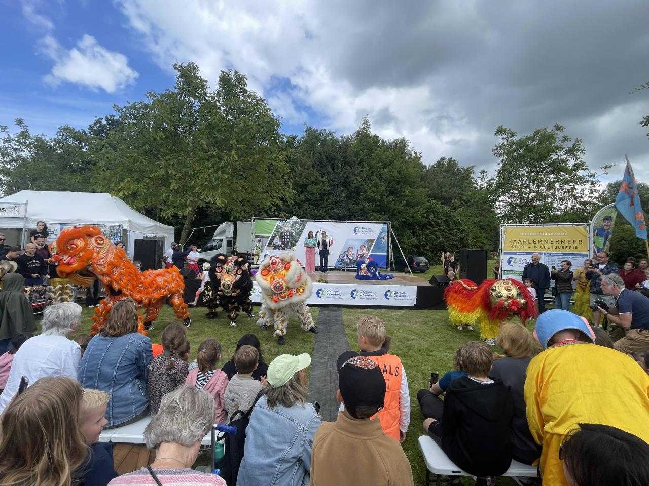 Grasvlakte met mensen en een podium