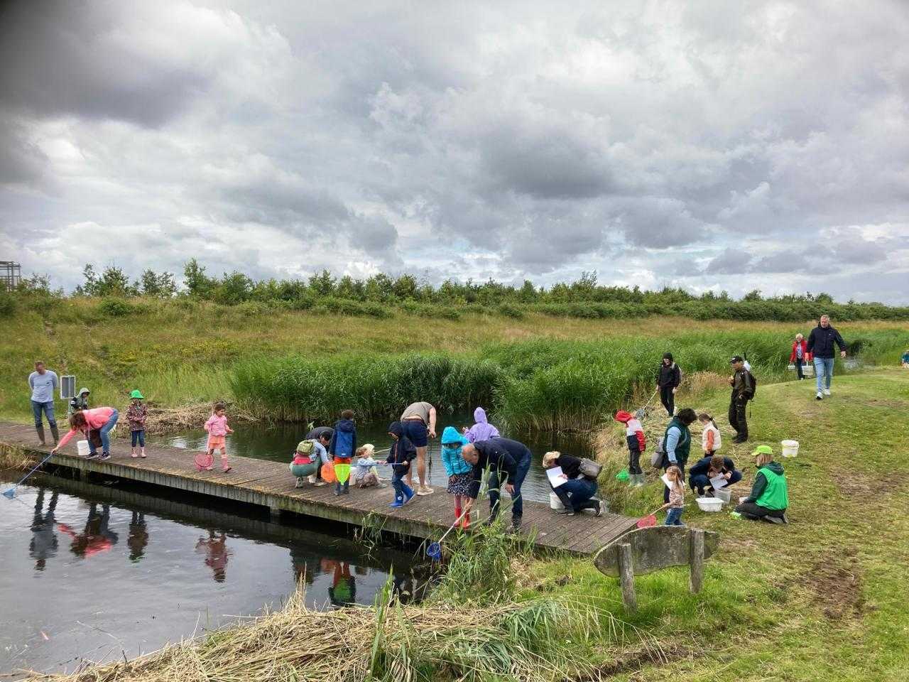Kinderen die meedoen aan de slootdag