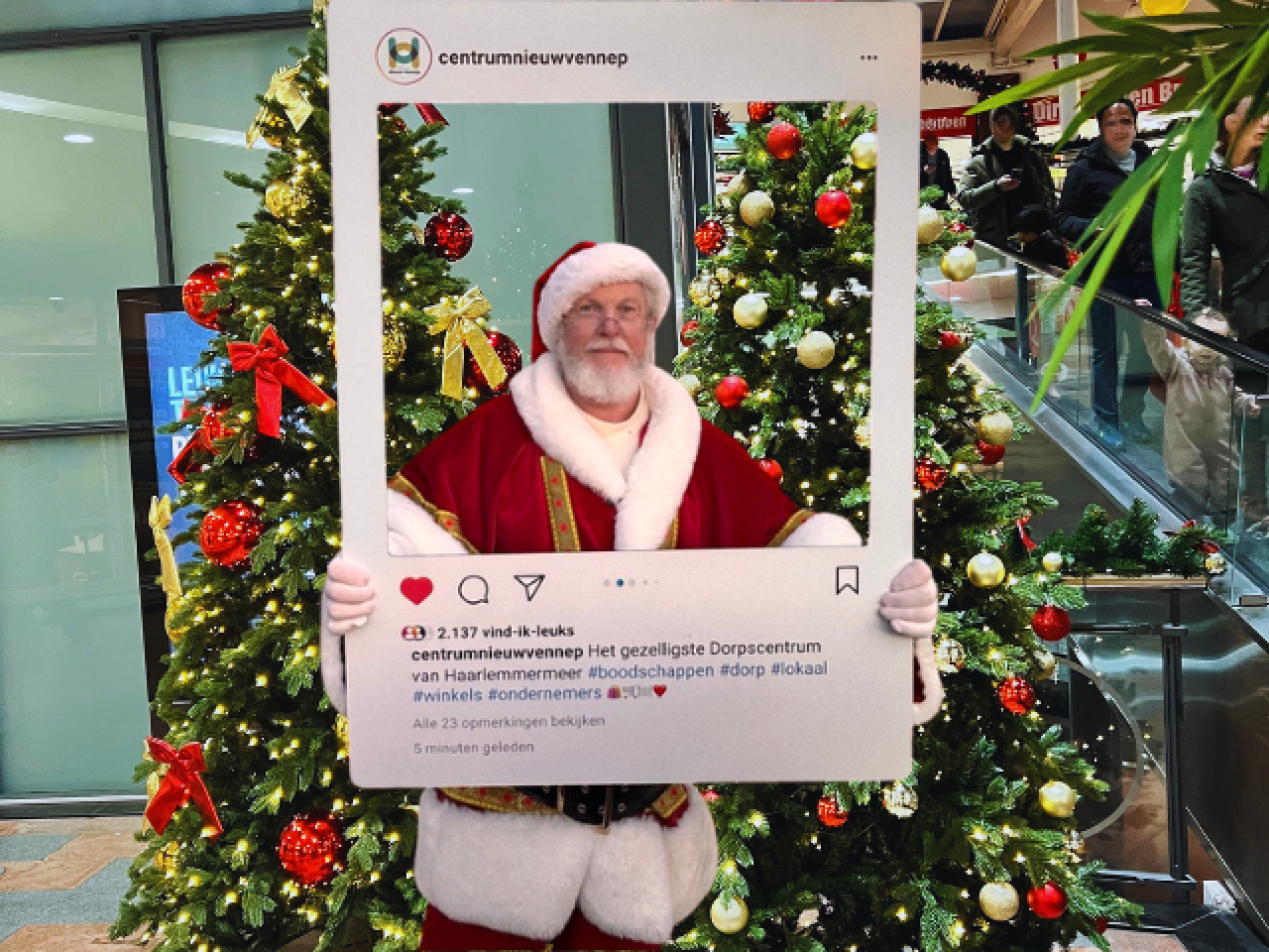 Kerstman poseert bij een kerstboom