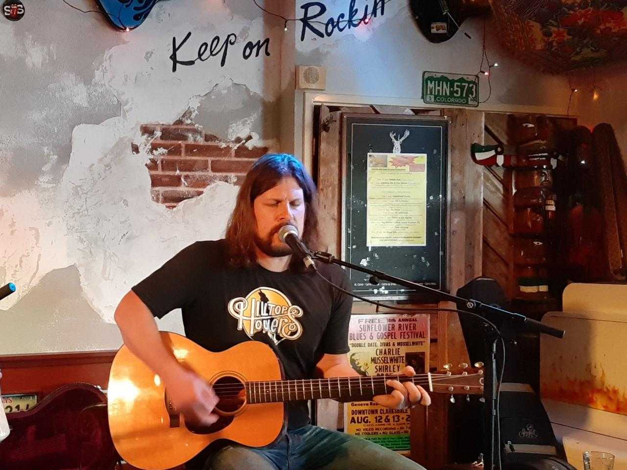 Lawrence Mul op het podium met zijn gitaar.